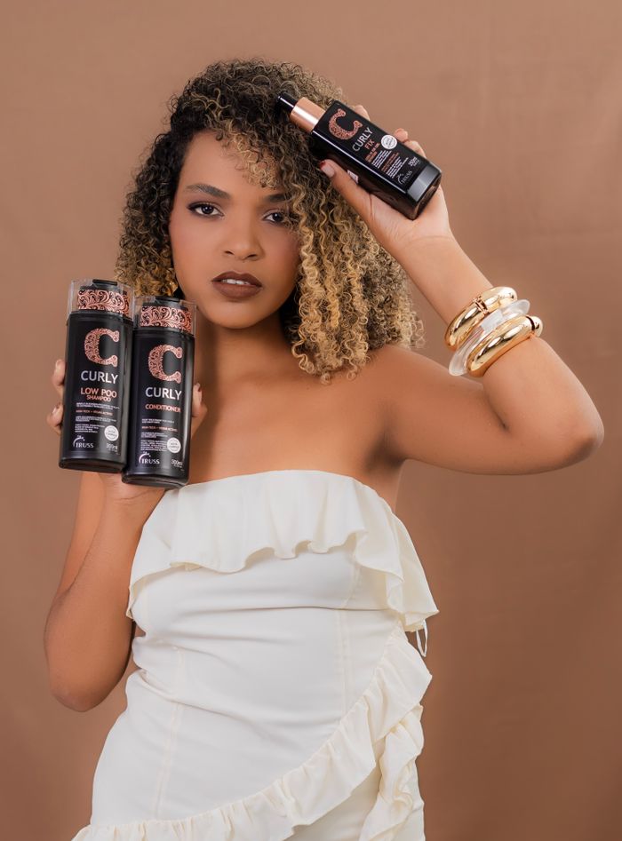 Portrait of a woman showcasing curly hair products, ideal for styling and hair care enthusiasts.