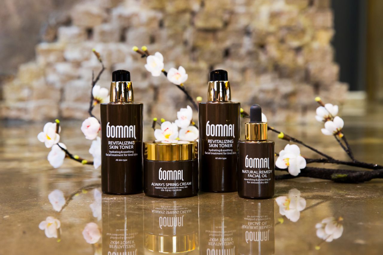 Sophisticated skincare product display with blossoms and reflections for beauty brands.