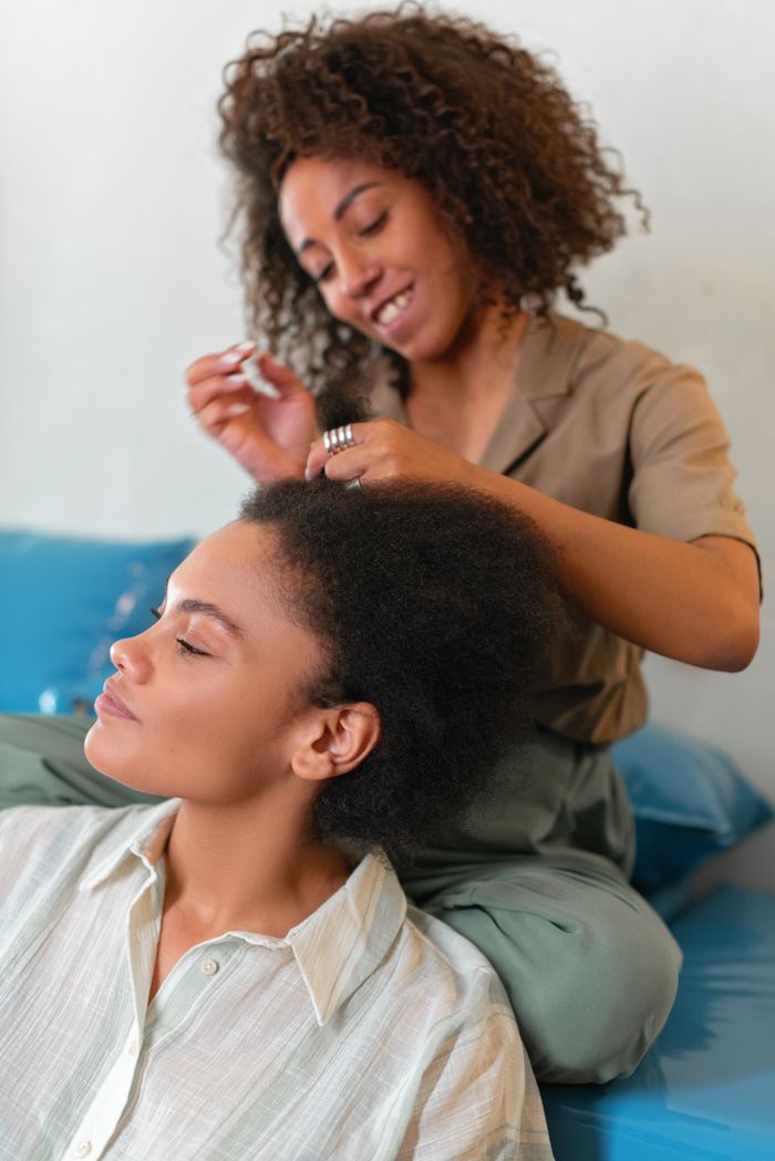 Home Two women enjoying an intimate moment styling hair and bonding together